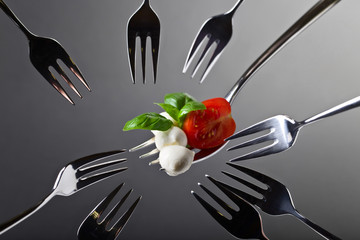 Mini mozzarella with tomato cherry and green basil .