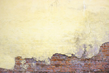 Old brick wall with peeling plaster, grunge background
