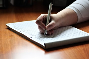 An Image of a Hand with pen - writing