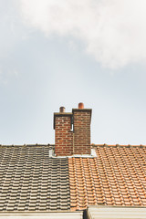 Two chimneys on different colored roofs
