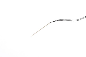 needle for sewing with black thread on white background