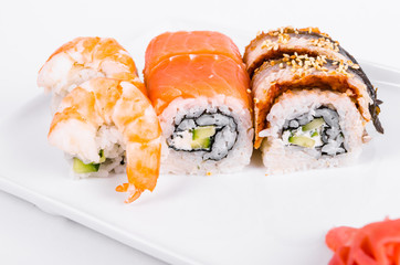 Asia. Tokyo rolls with shrimp, eel and salmon on a white plate on a white background