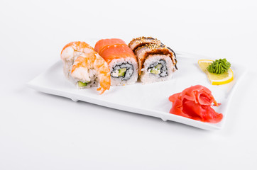 Asia. Tokyo rolls with shrimp, eel and salmon on a white plate on a white background