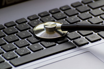 Computer or data analysis - Stethoscope over a computer keyboard toned in blue