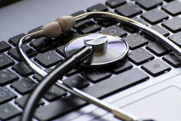 Computer or data analysis - Stethoscope over a laptop computer keyboard toned in blue