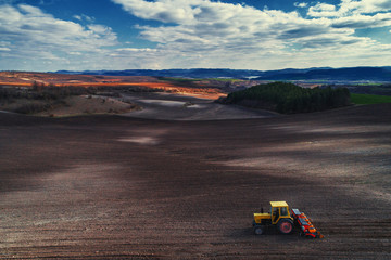 Aerial view of tractor working on the harvest field