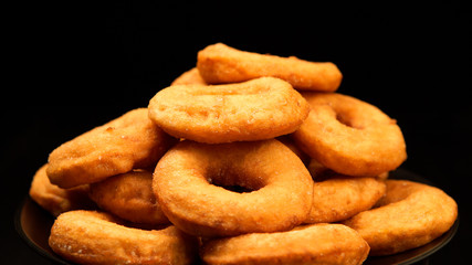 Fototapeta na wymiar Pile of a doughnuts on a black dish