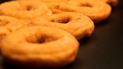 Row of doughnuts on a black table