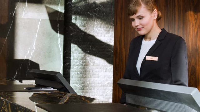 Smiling pretty female concierge answering service call