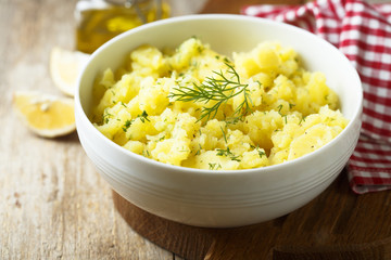 Potato salad with fresh dill in white bowl