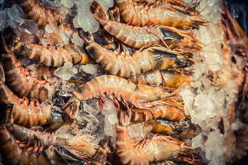 Fresh shrimp prawns with ice at the market for sell. Shrimps Top view.