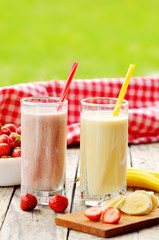 Banana and strawberry milkshake smoothie in the glass with straw