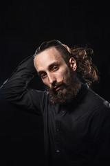 Studio portrait of a handsome man with a beard in the black shirt