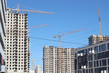 Fototapeta na wymiar Construction of a house in the city. Building construction process, building tower cranes against sky background.