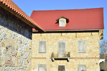 Traditional house built of stone,red roof tiles,sealed windows
