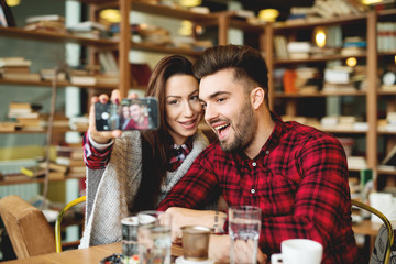 Self portrait making at restaurant couple enjoying together. Photo mobile posing for social networks.