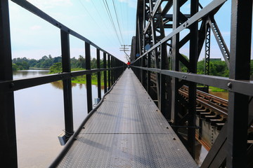 Naklejka premium sidewalk and motorbike roadside path steel train bridge vintage. select focus with shallow depth of field.