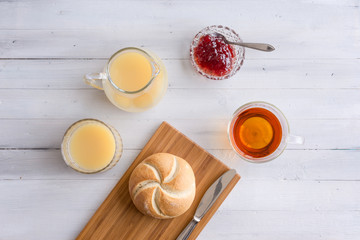 Breakfast morning table with bread, fresh juice and tea with lemon.