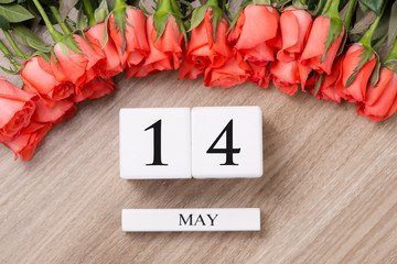 Cube shape calendar for MAY 15 on wooden table with roses