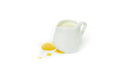 Obraz na płótnie Canvas Milk jug and honey on white background