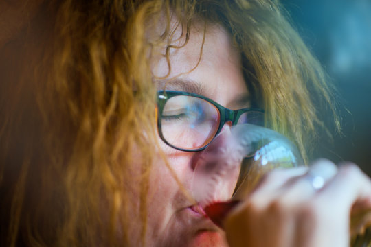eine Frau trinkt ein Glas Rotwein