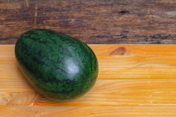 watermelon green fresh from the garden on a brown wooden background select focus with shallow depth of field.