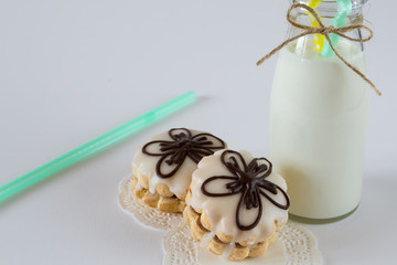 Biscuit decorative cookies with jam and glaze, with  milk on white background