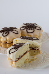 Homemade sandwich cookies with jam and glaze on white background