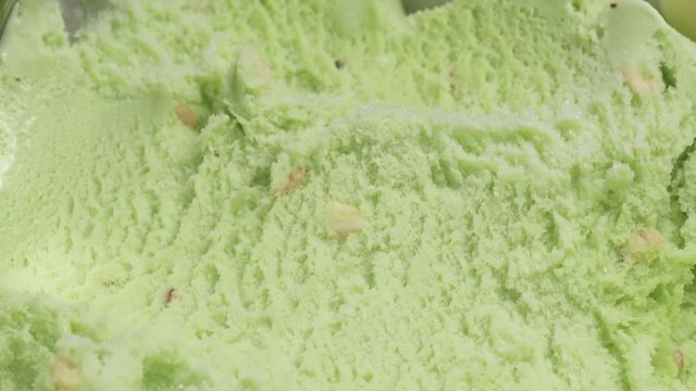 Slow motion of pistachio ice cream being scooped with spoon close up, 180fps prores footage