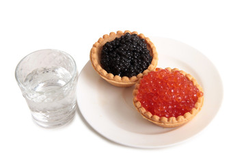 Fish caviar and glass of vodka on white background