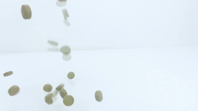 medical, vitamins, food supplement pills falling in slow motion on white background, health care diet concept