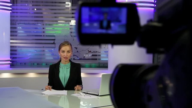 News Studio.Young and beautiful girl reading news on television.