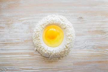 Ingredients and tools for baking - flour, eggs and glass of milk on the wooden rustic table background, selective focus