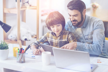 Father and son looking at digital tablet