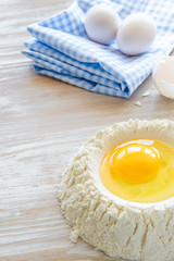 Ingredients and tools for baking - flour, eggs and glass of milk on the wooden rustic table background, selective focus