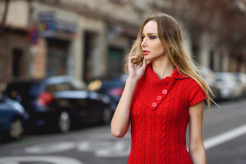 Young blonde woman looking at something in the street