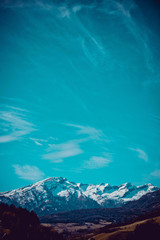 Photo depicting a beautiful moody frosty landscape. European alpine mountains with snow peaks on a blue sky background.