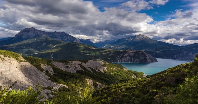 Serre-Poncon with the lake and the Grand Morgon Pic in summer. Hautes-Alpes time-lapse with passing clouds, Southern French Alps, France