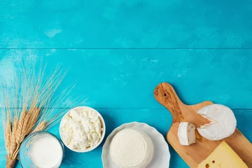 Foto op Plexiglas Zuivelproducten Melk en kaas, zuivelproducten op houten blauwe achtergrond. Joodse feestdag Shavuot concept. Uitzicht van boven