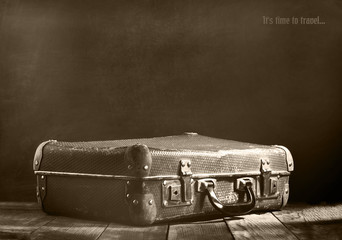 Old vintage suitcase on a wooden floor.Sepia toning