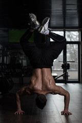 Fototapeta na wymiar Athlete Doing Extreme Push Ups On Floor Handstand