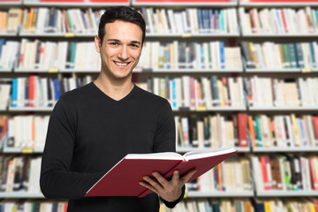 Guy reading a book in a library