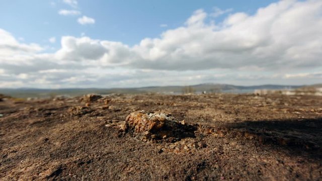 Soil Closeup. Vast Blurry Land on Background. Moving Shadow on Ground Coming, Going Away. Clouds on Sky