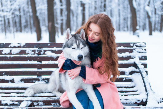 Woman sitting on the bench with siberian husky