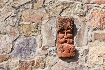 old medieval stone wall with face of baccus, the god of winery