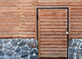 Wooden door to the utility room of a house standing on a stone foundation