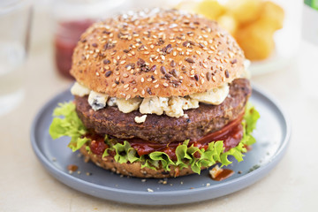 Angus burger on grain bun with tomato relish, lettuce and blue cheese 