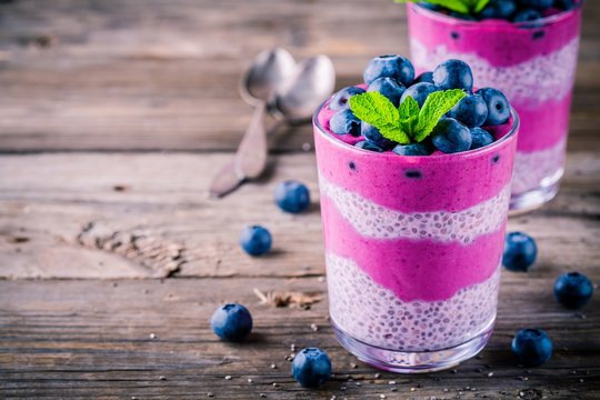 Blueberry smoothies with chia pudding in glasses with fresh berries and mint