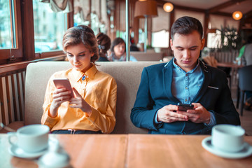 Love couple use their mobile phones in restaurant