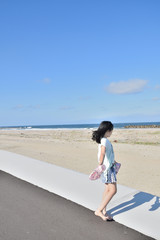 Dancing barefooted girl. Background,coast,blue,sky.
